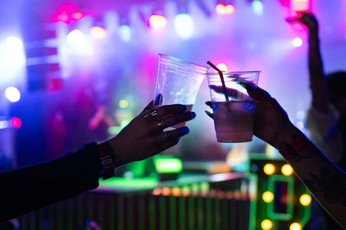 Two people with drinks in their hands, having a toast at a party.
